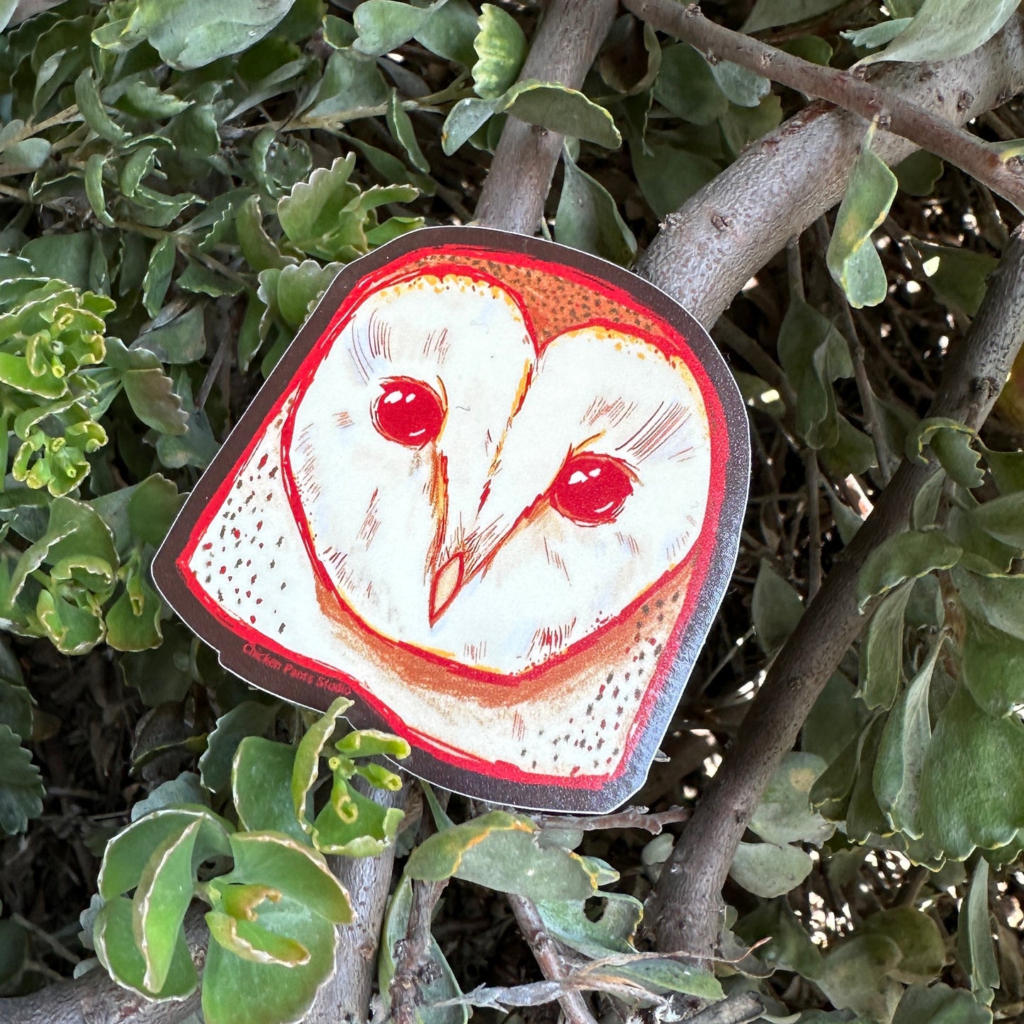 Circular sticker with owl design on a branch
